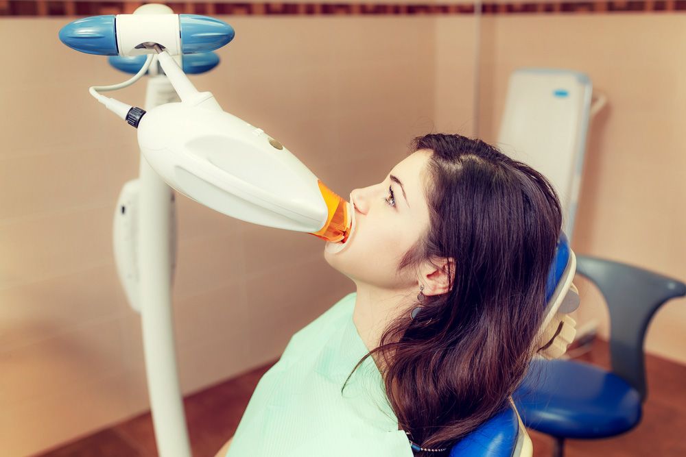 Female patient undergoing whitening with a special light