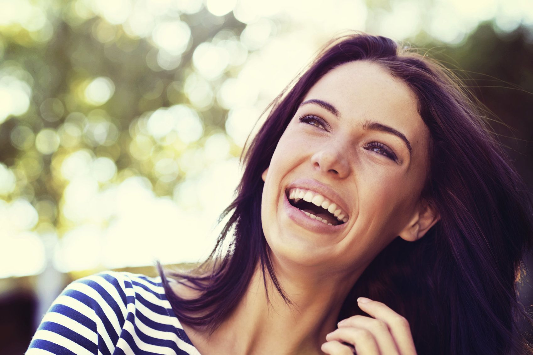 Dark-haired woman smiling outdoors